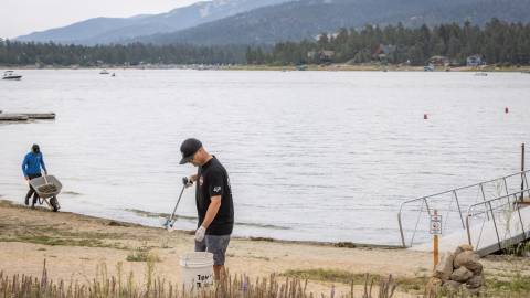 A pair of volunteers scanning the Big Bear Lakeside for any trash to clean up as efforts to Care For Big Bear.