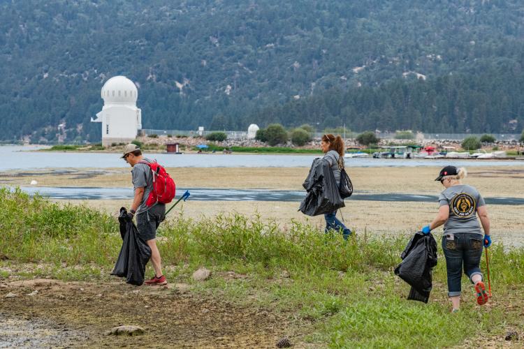 Volunteers collect trash from the shoreline of Big Bear Lake during a Care For Big Bear clean up event.