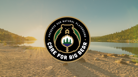 A circular digital logo of the Care For Big Bear movement, stating to preserve our natural playground with a lake backdrop.