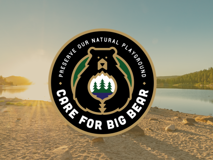 A circular digital logo of the Care For Big Bear movement, stating to preserve our natural playground with a lake backdrop.