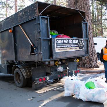 NativeScapes partners with Care For Big Bear to haul away bags of trash from a picnic area.