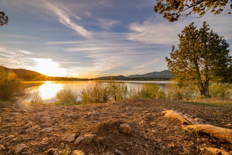 A golden sunrise on the shore of Juniper Point in Big Bear Lake California - the lake waters reflecting the sunshine.