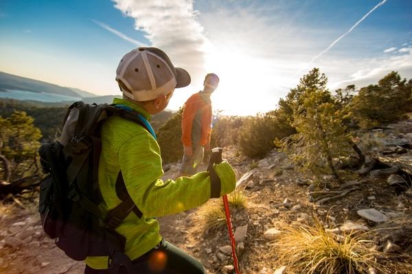 A photo of a son and father hiking on a mountain just before sunset.