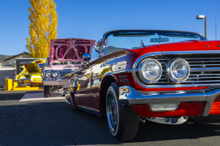 Lowriders positioned one after another going away from the viewer during the Lowrider Kickback at the Big Bear Visitor Center