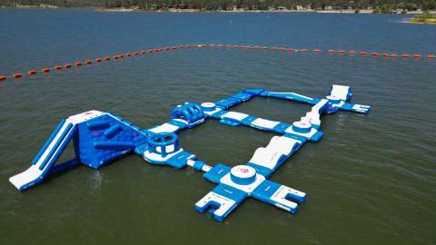 A drone shot of the Pineknot Marina's Big Bear Lake Watersports School floating water park wipe out course.