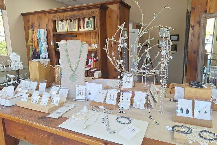 A large table display showcasing the Silver Fawn's jewelry - there are bracelets, ear-rings, and necklaces.