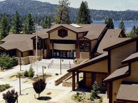 An aerial image of Big Bear Lake City Hall. The blue lake and green forest are visible in the background.