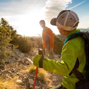 A photo of a son and father hiking on a mountain just before sunset.