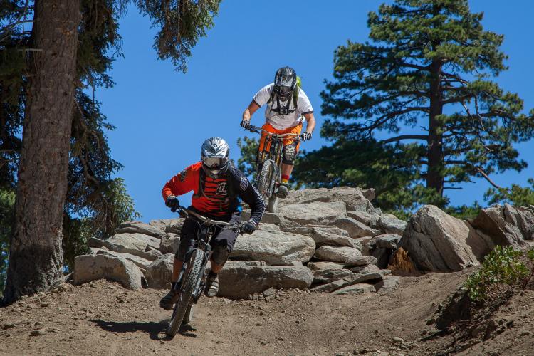 Mountain bikers speed down the Snow Summit Bike Park