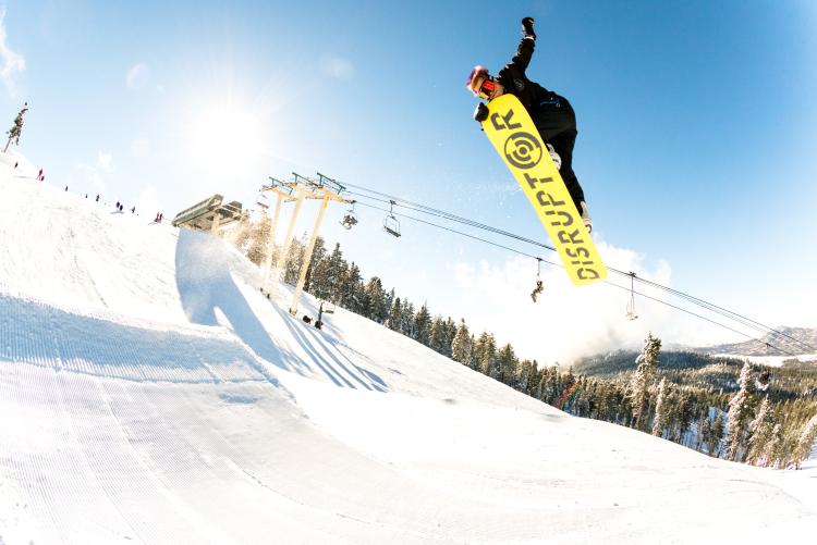 A snowboarder hits a jump at Bear Mountain