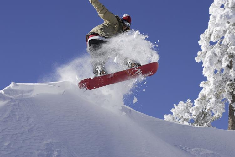 A snowboarder catches air on the slopes