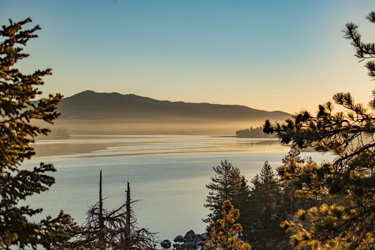 A photo taken during a golden hour in Big Bear Lake, the fog and lake water gently reflecting the gold-ish light.