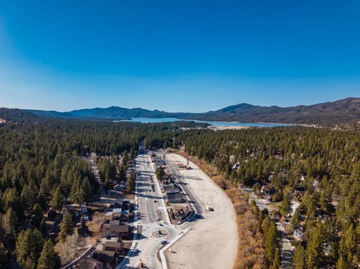 An aerial drone shot of the Moonridge Corridor, the fall colored leaves, mountains and lake are visible in the distance.