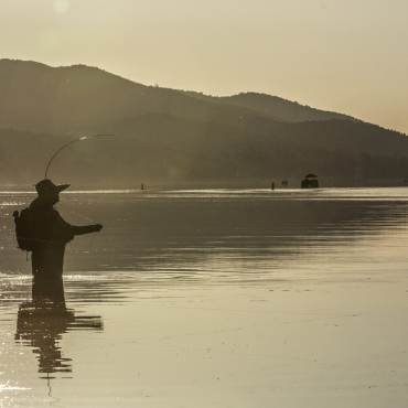 A wading angler patiently awaits his catch big bear lake