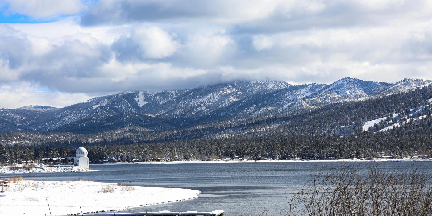 A photo of the Big Bear Lake during the winter, the fresh snow covered ground and observatory visible in the distance.