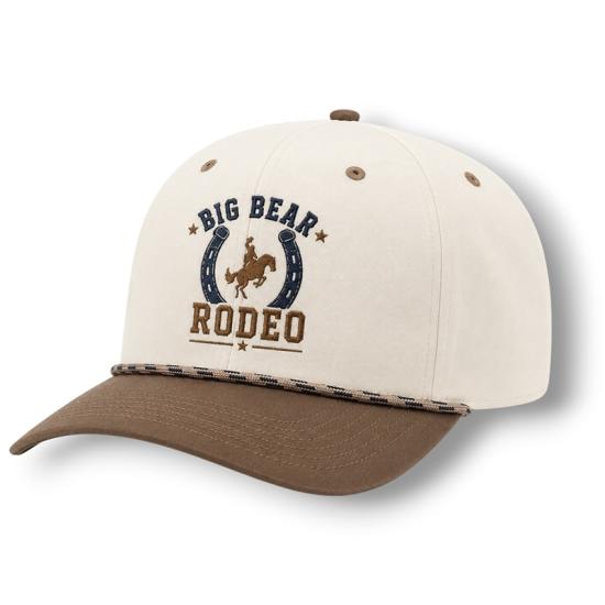 A white and brown hat sold during the Big Bear Lake Rodeo - the front has a horseshoe surrounding a cowboy and his horse.