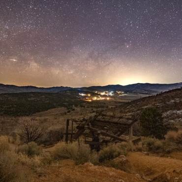 An image of the stars and Milky Way galaxy in the night sky over Big Bear. An old mining shaft sits in the foreground.