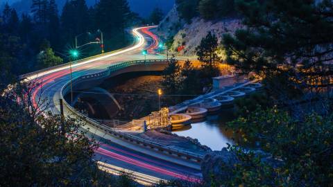 red car light trails follow the path of a road in Big Bear at night