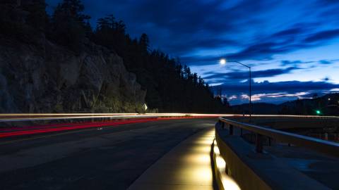 A mountainside road at night, illuminated by street lights and car headlights, in Big Bear Lake, CA.
