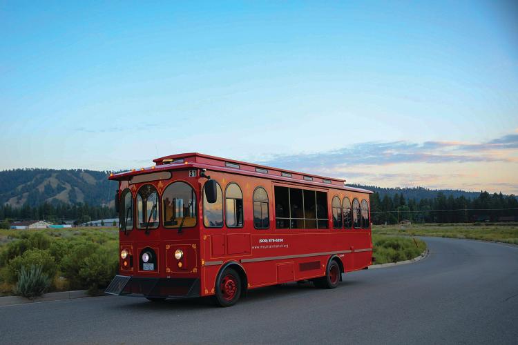 a red Mountain Transit trolley transports riders through Big Bear Lake