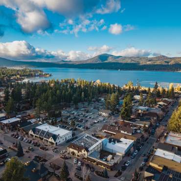 An aerial drone shot of Big Bear Lake and the village - the lake and mountains are visible in the distance.