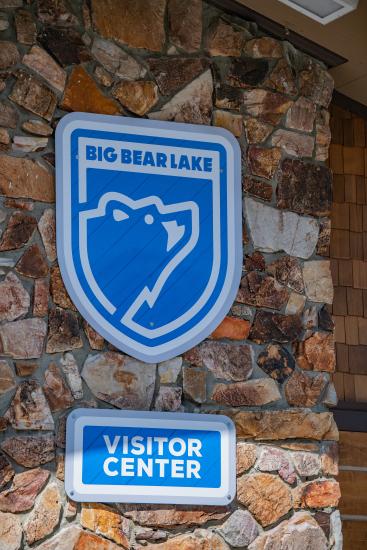 The blue Big Bear Lake logo sign mounted on the rock facade of the Big Bear Lake Visitor Center
