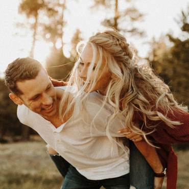 A man carries his fiancé on his back during a playful engagement shoot in Big Bear Lake, CA.