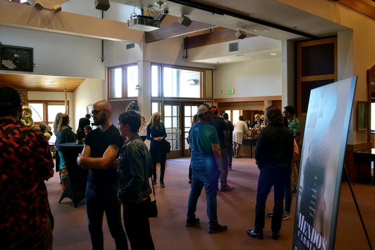 A large crowd gathered for a Film Festival in Big Bear Lake California - there is a movie poster in the middle of the room.