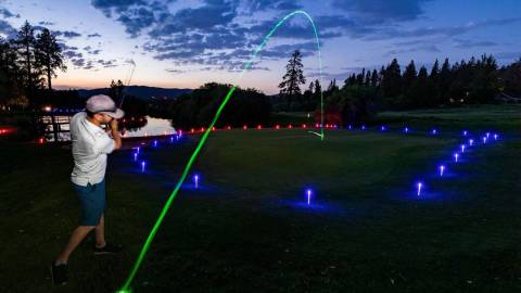 A photo of Bear Mountain Resort's Glow Golf, the brightly colored green ball flying through the air.