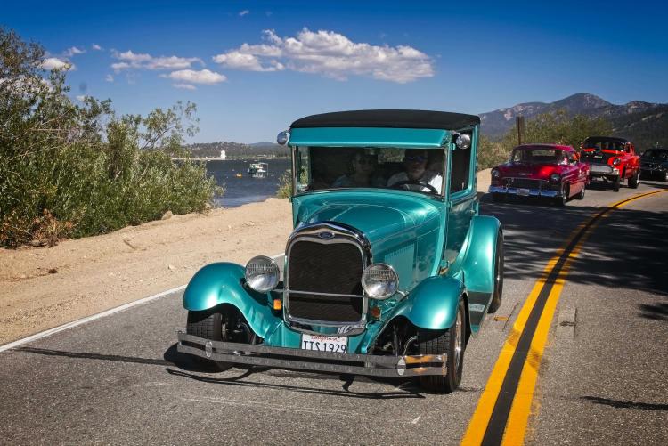 A blue antique car drives near the water of Big Bear Lake during the Big Bear Fun Run.