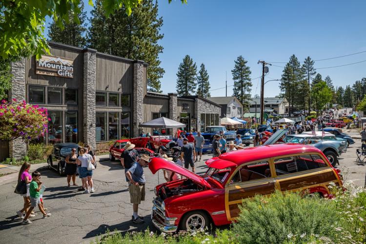 A photo taken during the Big Bear Fun Run - there are antique cars and people along the streets in the Big Bear Lake Village.