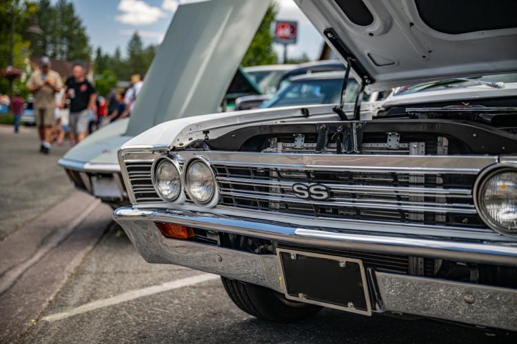 A photo of an antique car with it's hood opened during the Big Bear Fun Run - there are people walking in the background.