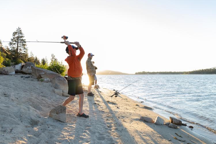 A young boy casts a fishing rod into Big Bear Lake during the Fishin' For $50K trout fishing tournament.