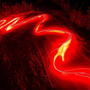 A stream of flaming torches lights a ski run during a New Year's parade in Big Bear, CA. Long exposure shot.