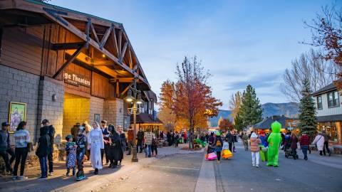 A photo of Halloween in the Big Bear Village - a crowd of Trick or Treaters are gathered in front of the Village Theaters.