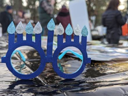 A pair of blue glasses with eight Hanukkah candles sits on a table during a Chanukah celebration in Big Bear Lake, CA