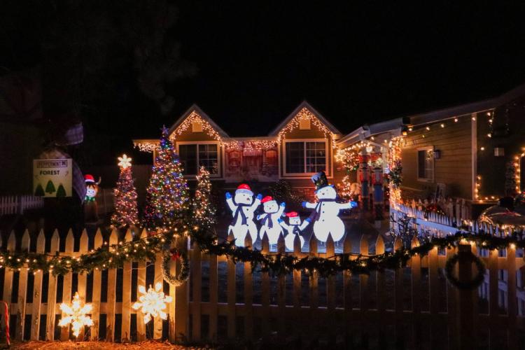 A photo of a Festival Of Lights display - the display prominently featuring snowmen, decorated trees, lights, and snowflakes.