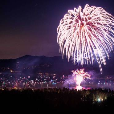 A fireworks display during 4th Of July above Big Bear Lake, the white streams of sparks and embers flying through the air.