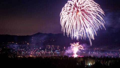 A fireworks display during 4th Of July above Big Bear Lake, the white streams of sparks and embers flying through the air.