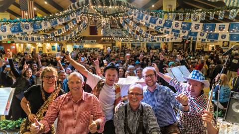 A large group of Oktoberfest goers wave to the camera at the Big Bear Lake Oktoberfest.