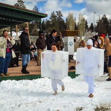Attendees wearing ice cube costumes run through the snow for the Big Bear Polar Plunge