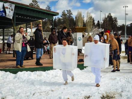 Attendees wearing ice cube costumes run through the snow for the Big Bear Polar Plunge