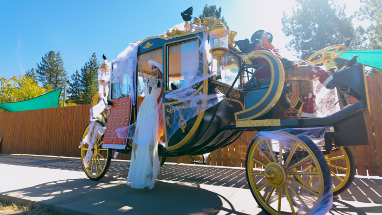 A photo of a scarecrow competition display, there are many scarecrows and skeletons on a carriage.