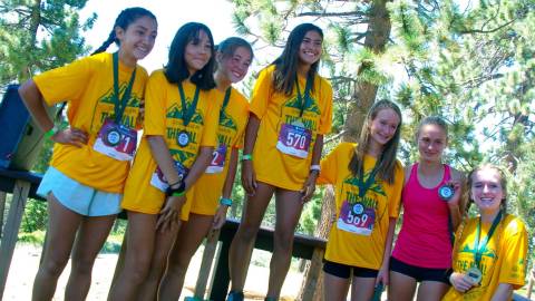 A group of girls wearing yellow t-shirts posing for awards at the Conquer The Wall event in Big Bear Lake California.