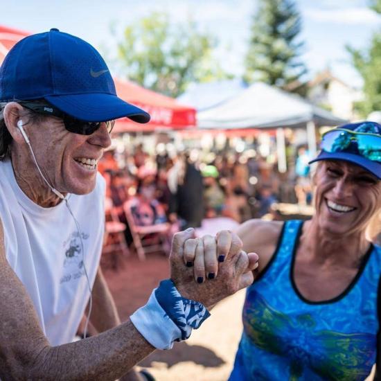 A man and woman hold hands and smile at the Big Bear Lake Kodiak 100