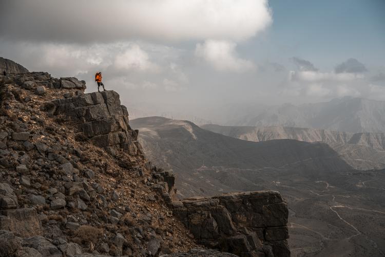A hiker looks out over a valley during a Highlander hiking event.