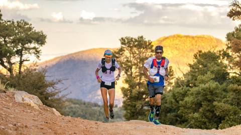 Two runners jog up a trail during the Kodiak 100 race in Big Bear Lake.