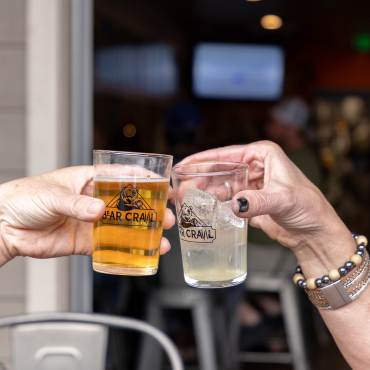 Two people's hands in the middle of a toast during the Big Bear Lake Bear Crawl event