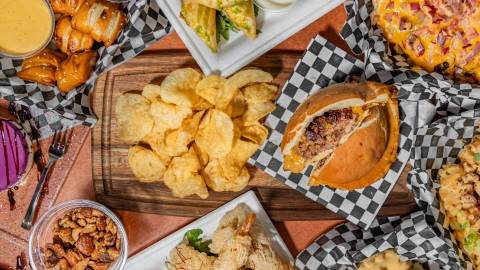 A top-down view of the Moonridge Room's food spread - there are appetizers surrounding a UFO / saucer shaped burger.