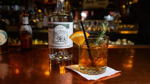 A photo of Captain's Anchorage's Negroni cocktail - their "snowgroni" is shown alongside the bottle of gin used in the drink.